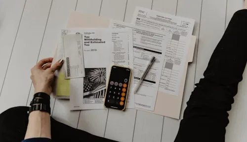 مستندات محاسبية وآلة حاسبة على مكتب